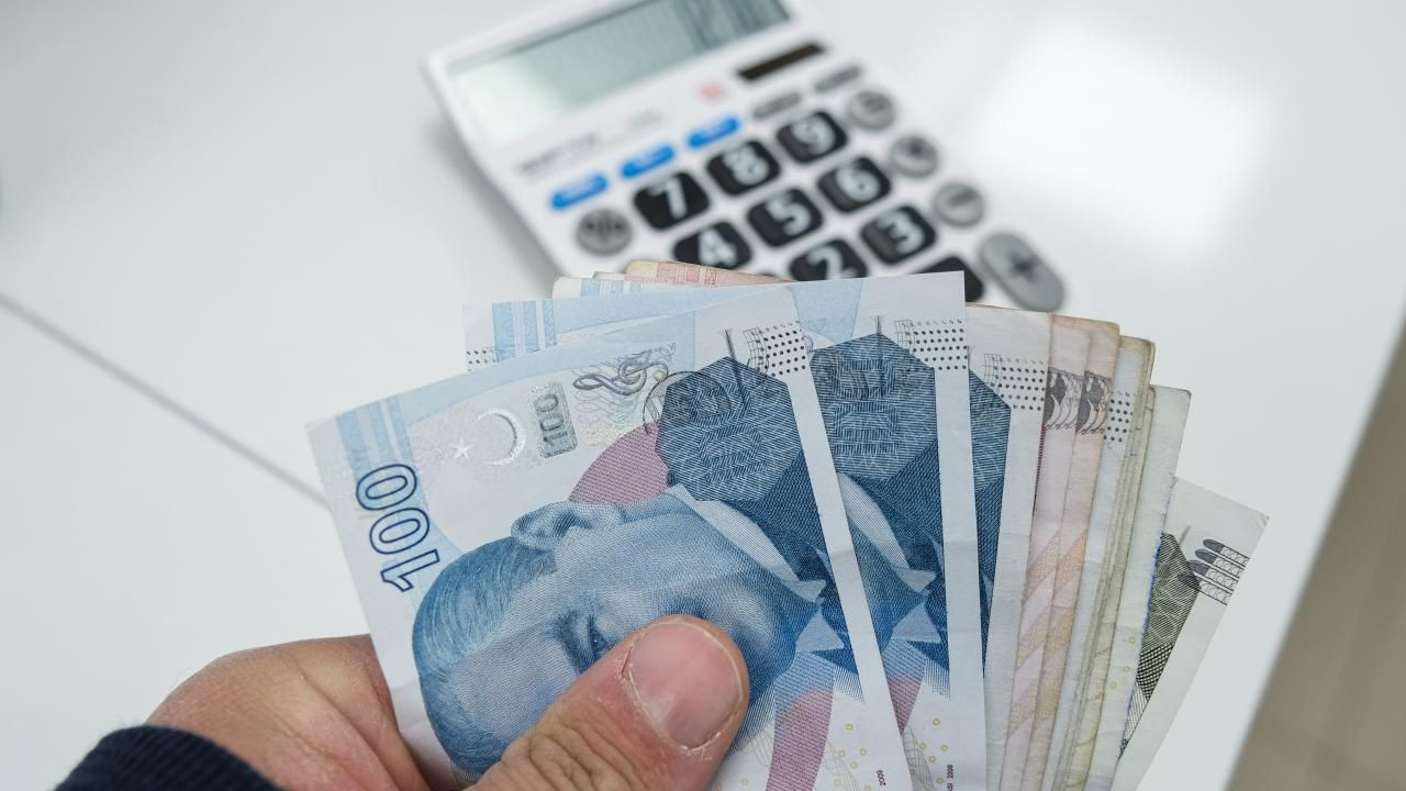 Türk lirası banknotlar ve hesap makinesiyle emekli promosyonu hesaplamasını çağrıştıran görsel.
