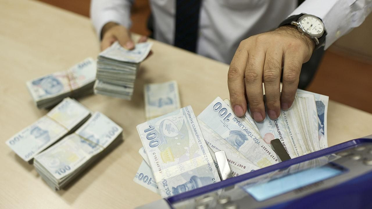 Bankada Türk lirası banknotların sayıldığı gişe görünümü.