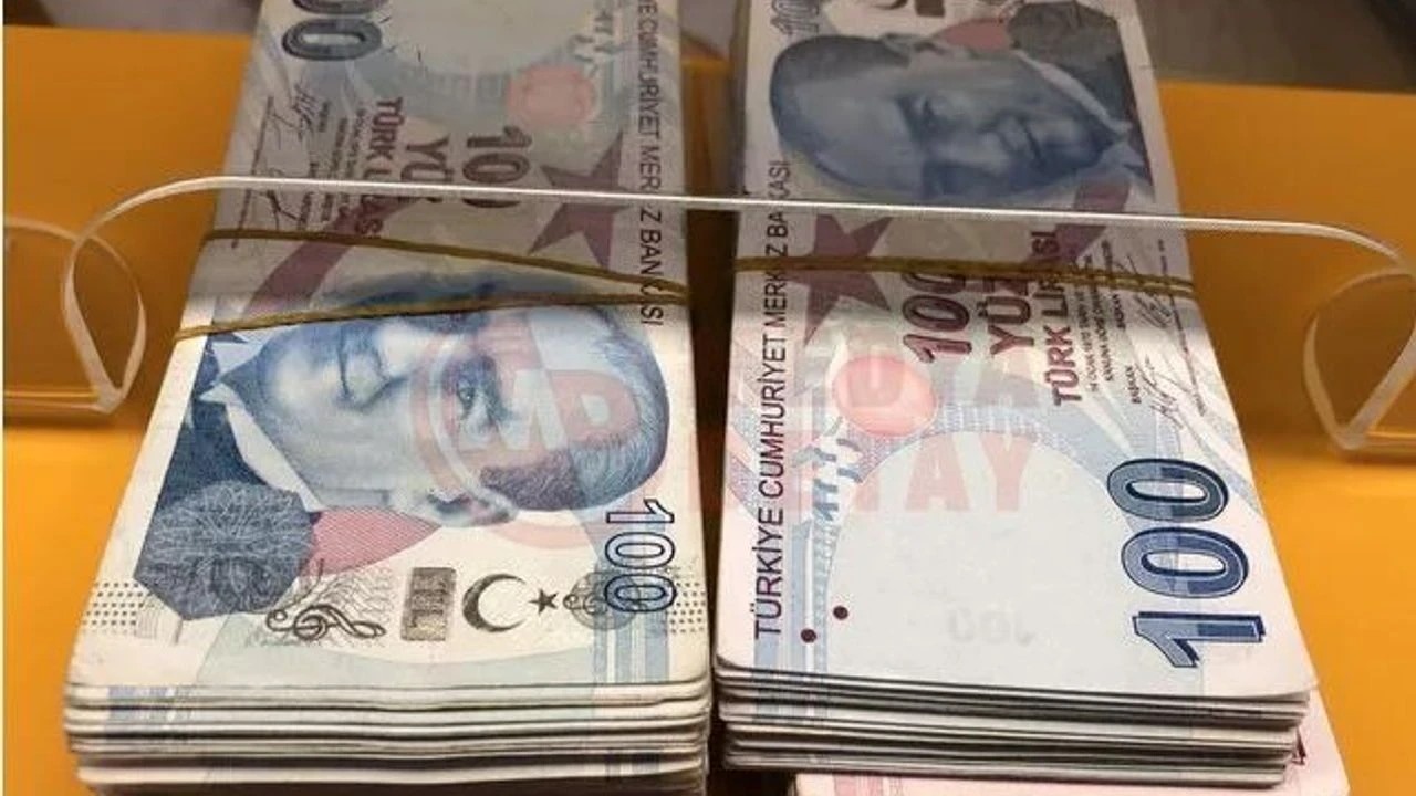Banka gişesinde lastikle bağlanmış 100 TL banknot desteleri.