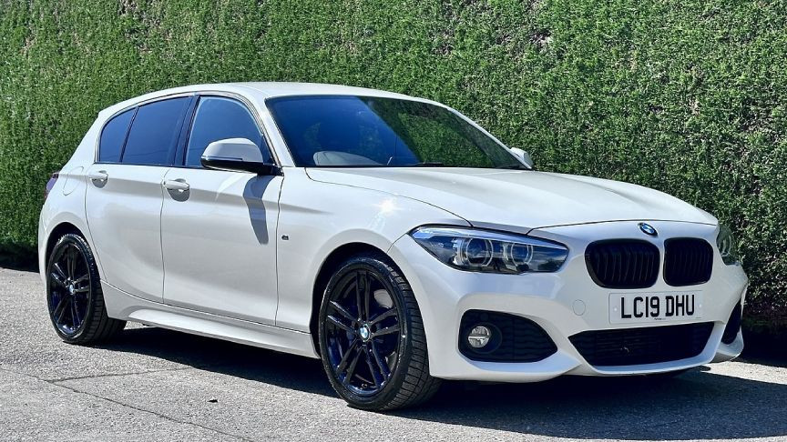 Park halindeki beyaz BMW 1 Serisi otomobil.