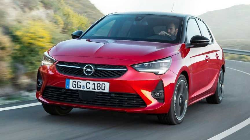 Yolda ilerleyen kırmızı Opel Corsa otomobil.