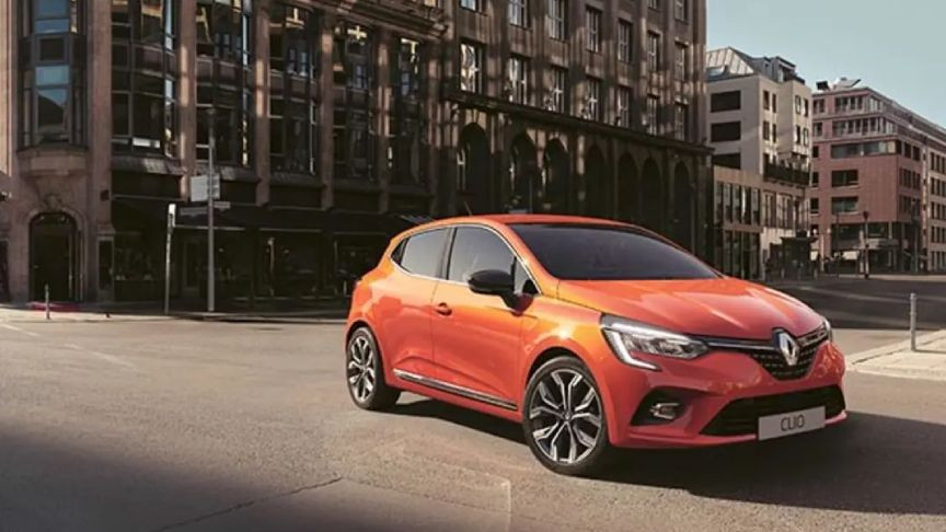 Şehir içinde duran turuncu Renault Clio otomobil.