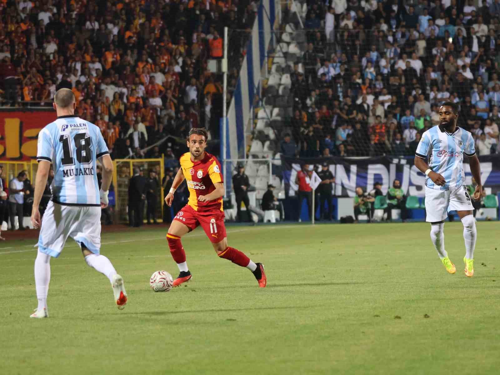 Galatasaraylı futbolcu topu taşırken Erzurumspor FK oyuncuları savunmada.