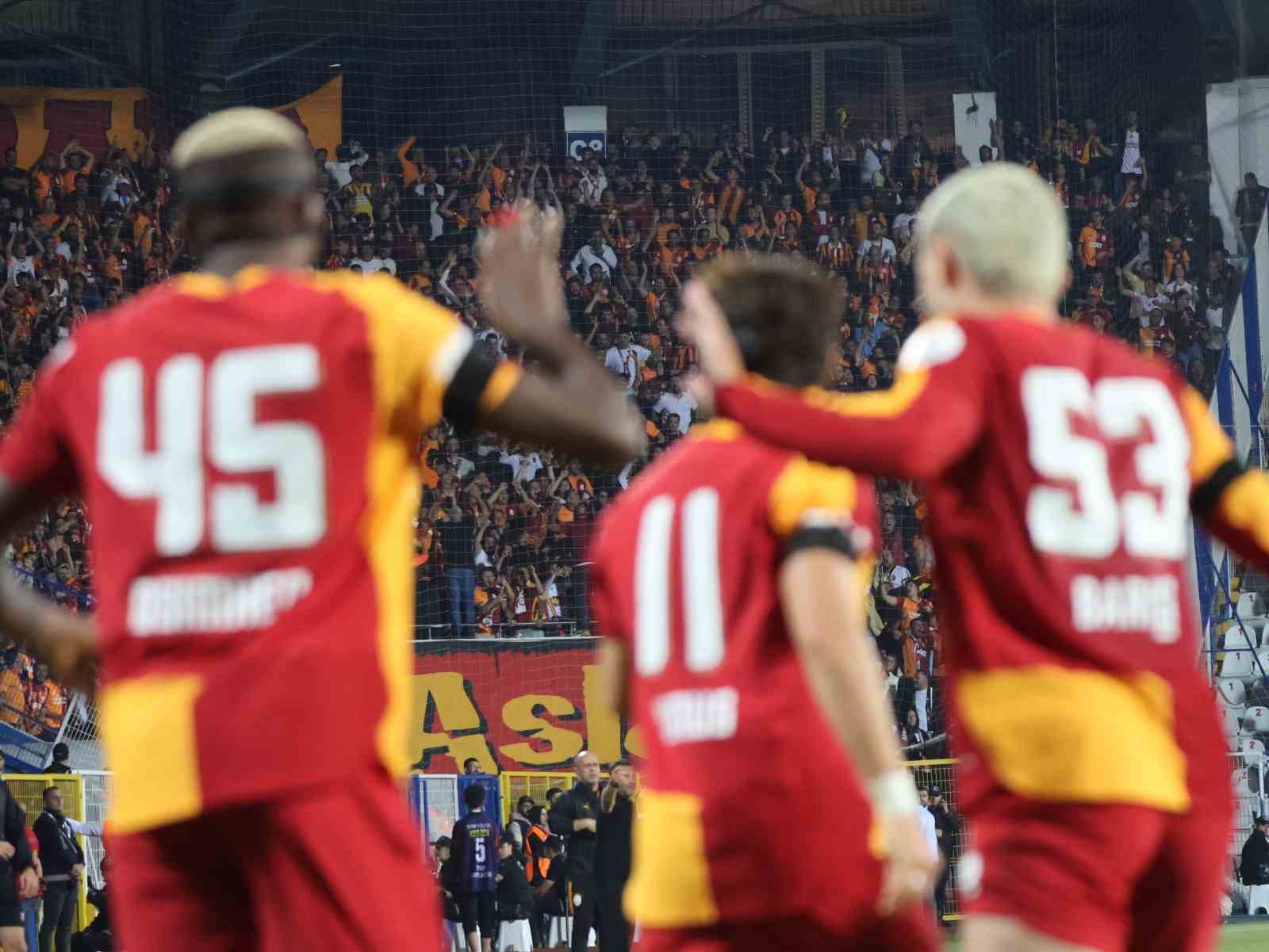 Galatasaraylı futbolcular tribünlere doğru bakarken görülüyor.