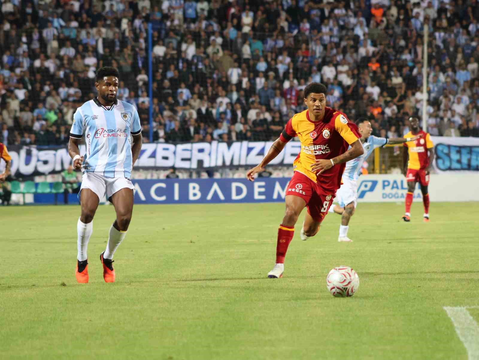Galatasaraylı futbolcu topla ilerliyor, Erzurumspor FK oyuncusu takip ediyor.