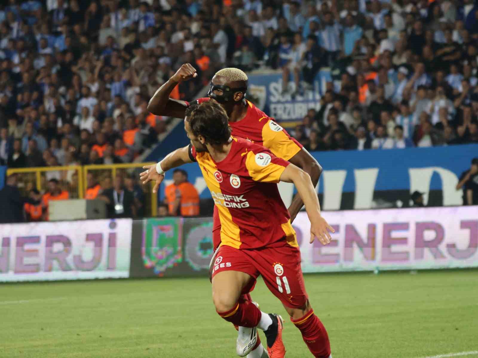 Galatasaray forması giyen iki oyuncu gol sevinci sırasında.
