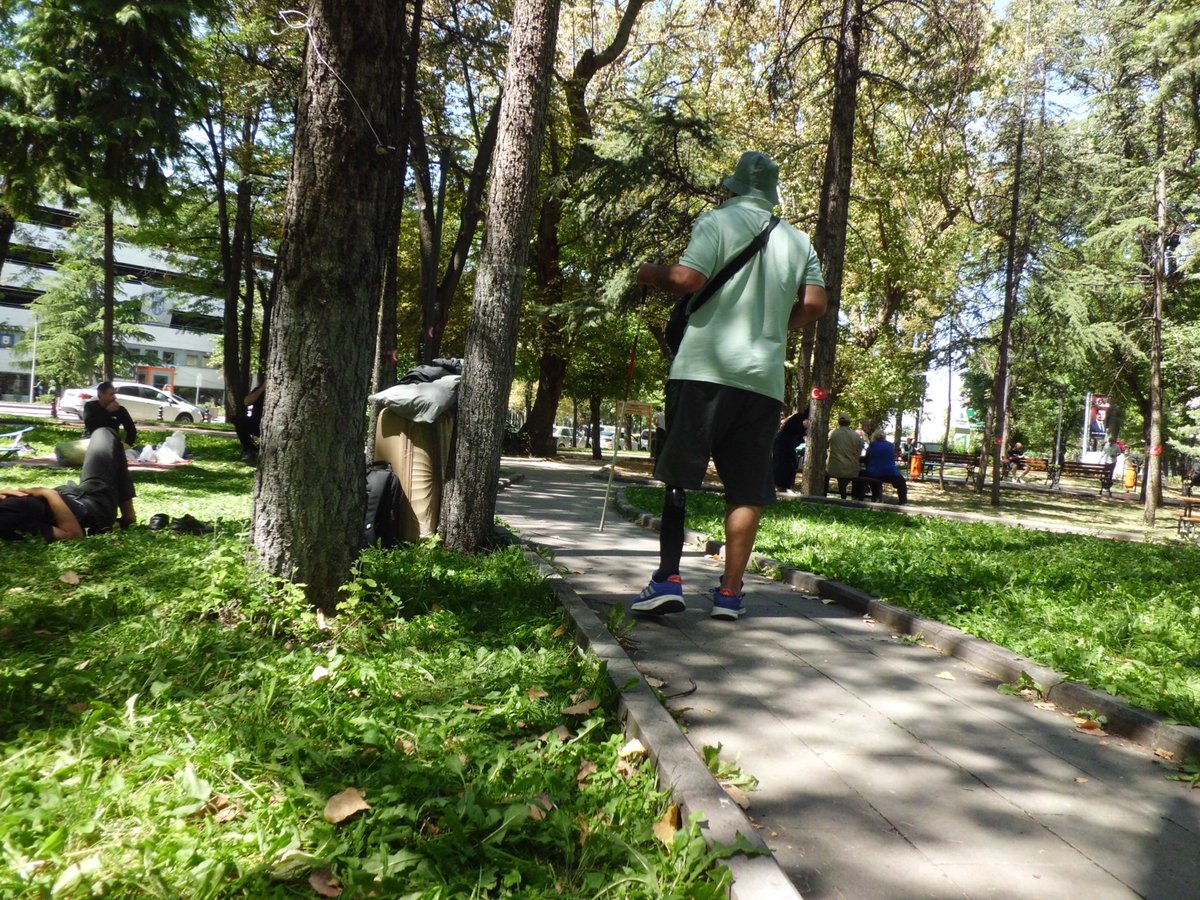 Kurtuluş Parkı’nda yürüyüş yolunda duran bir gazi ve çevrede bekleyen kişiler.