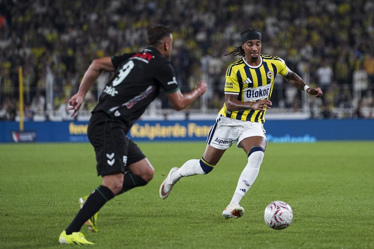 Fenerbahçeli futbolcu, Konyasporlu rakibi karşısında topu taşıyor.