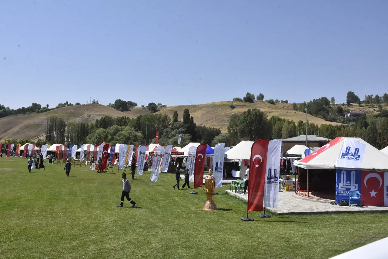 Ahlat’ta geniş bir alana kurulmuş çadırlar, bayraklar ve etkinlik alanında dolaşan ziyaretçiler görülüyor.