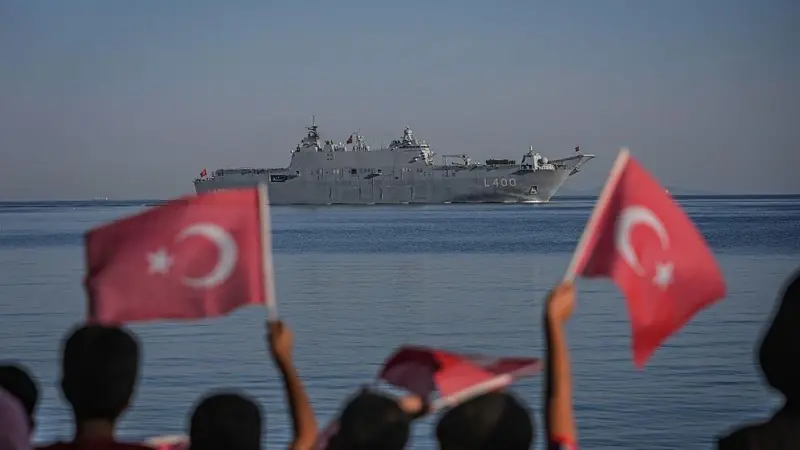 Çocukların Türk bayraklarıyla izlediği deniz geçişinde TCG Anadolu denizde ilerliyor.