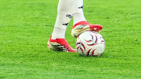 Futbol topunun üzerinde duran kramponlu ayak.
