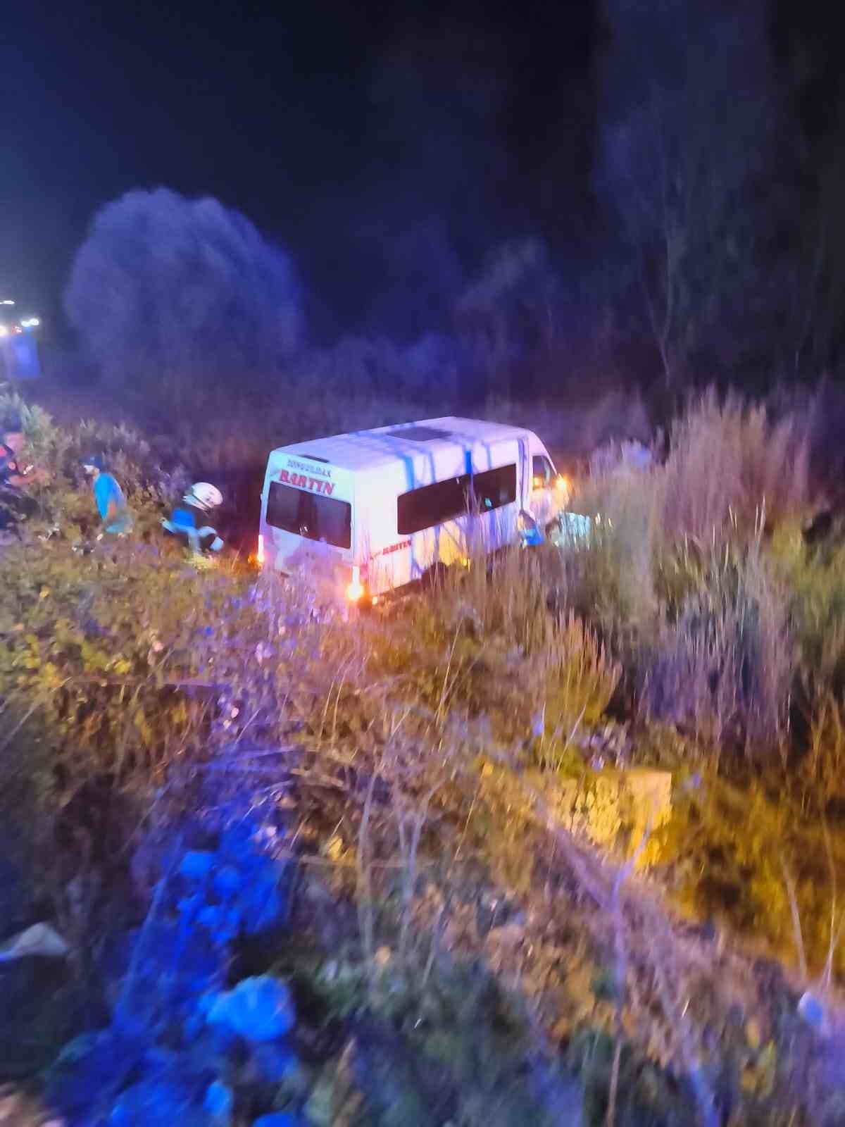 Gece saatlerinde şarampole sürüklenen yolcu minibüsü ve çevrede çalışma yapan ekipler görülüyor.