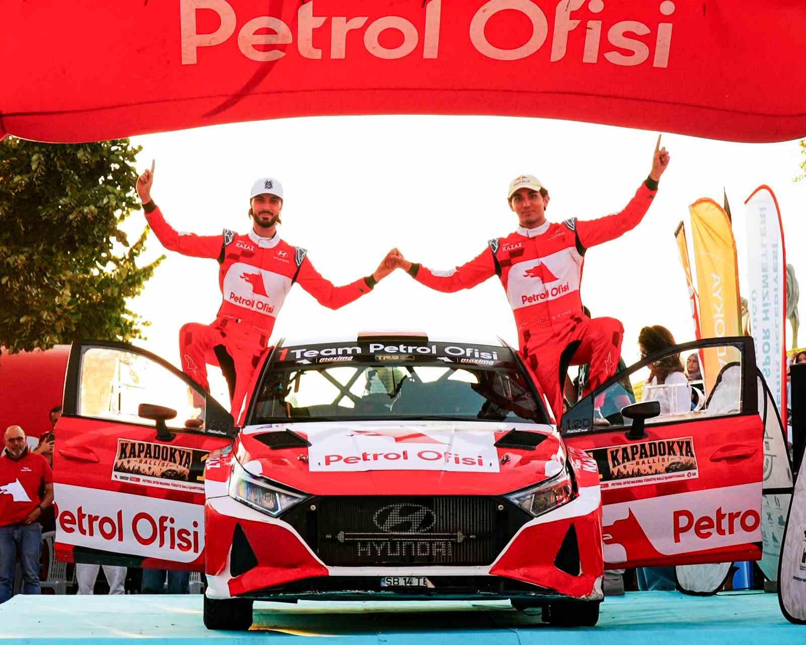 Team Petrol Ofisi pilotları Kerem Kazaz ve Corentin Silvestre, yarış otomobilinin üzerinde zafer pozu veriyor.
