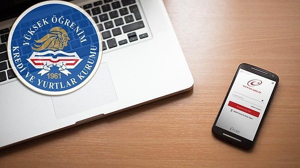 KYK amblemi, bilgisayar ve e-Devlet ekranı görülen masa düzeni.