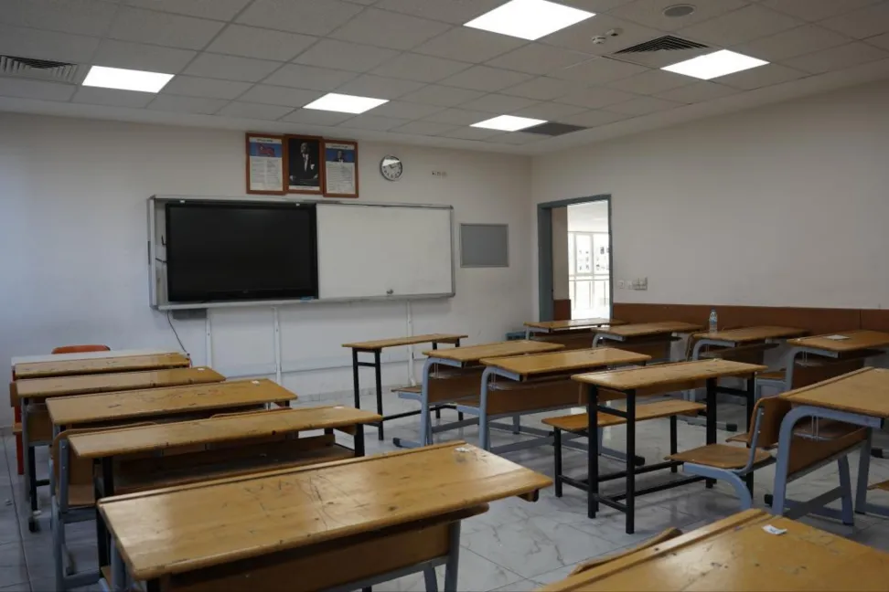 Boş sınıf sıraları ve akıllı tahtanın bulunduğu bir derslik.