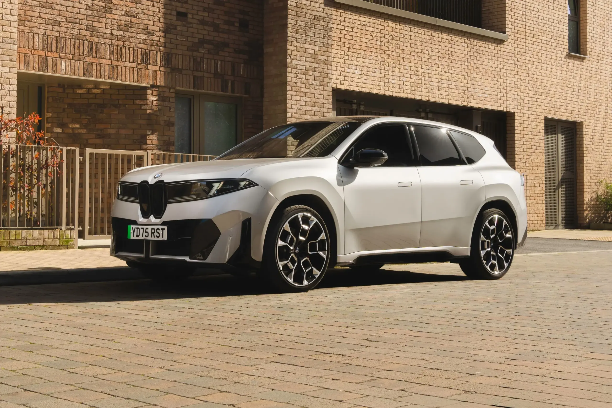 Beyaz renkli BMW SUV modelinin bina önünde park halinde dış görünümü.
