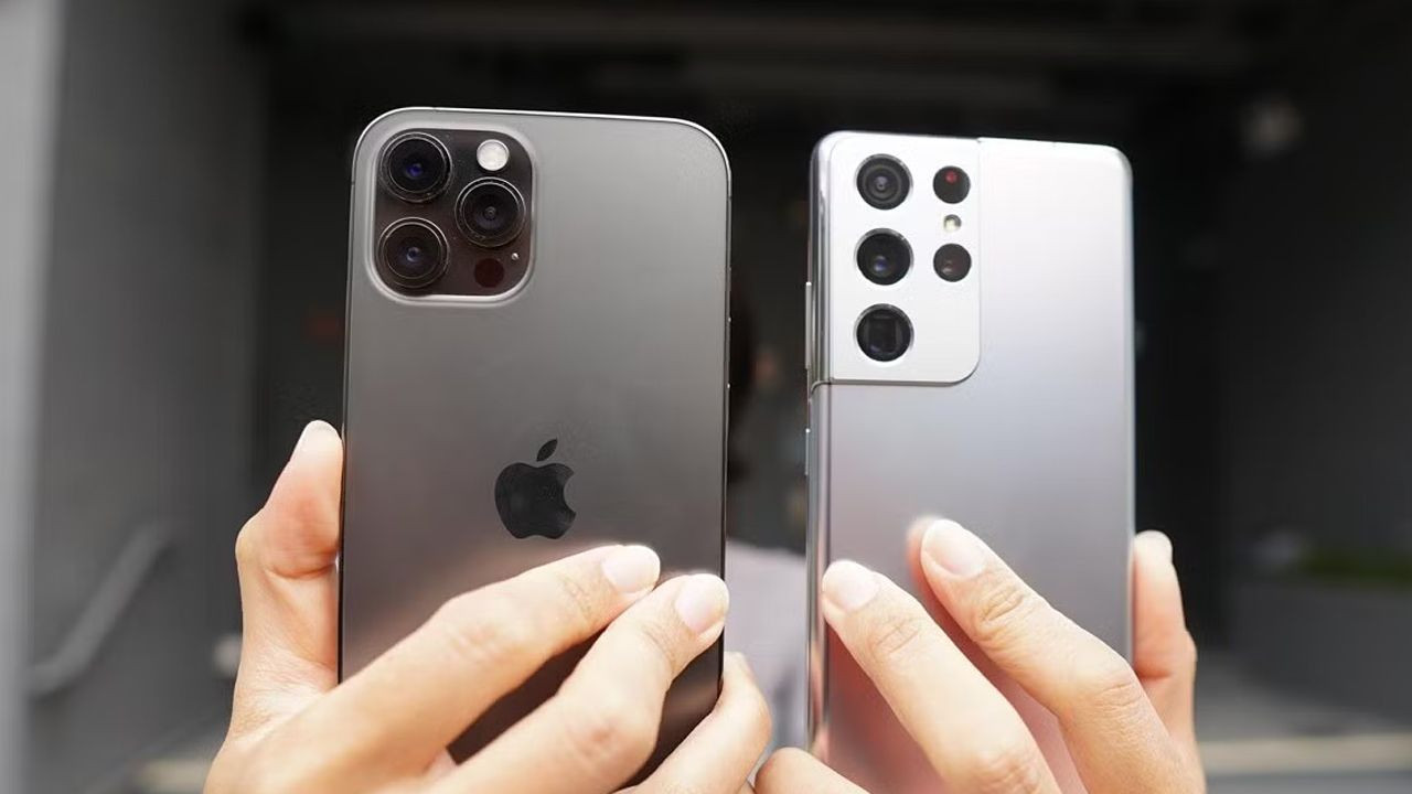 Apple and Samsung smartphones held in hand.