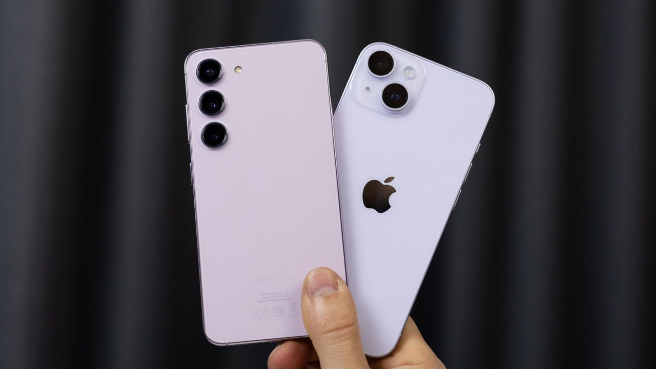 Image of an Apple and a Samsung phone held in hand.