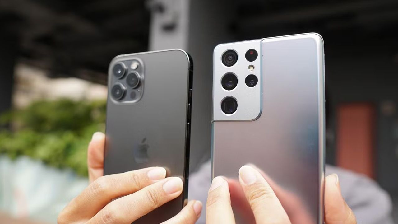 Apple and Samsung phones held in hand.