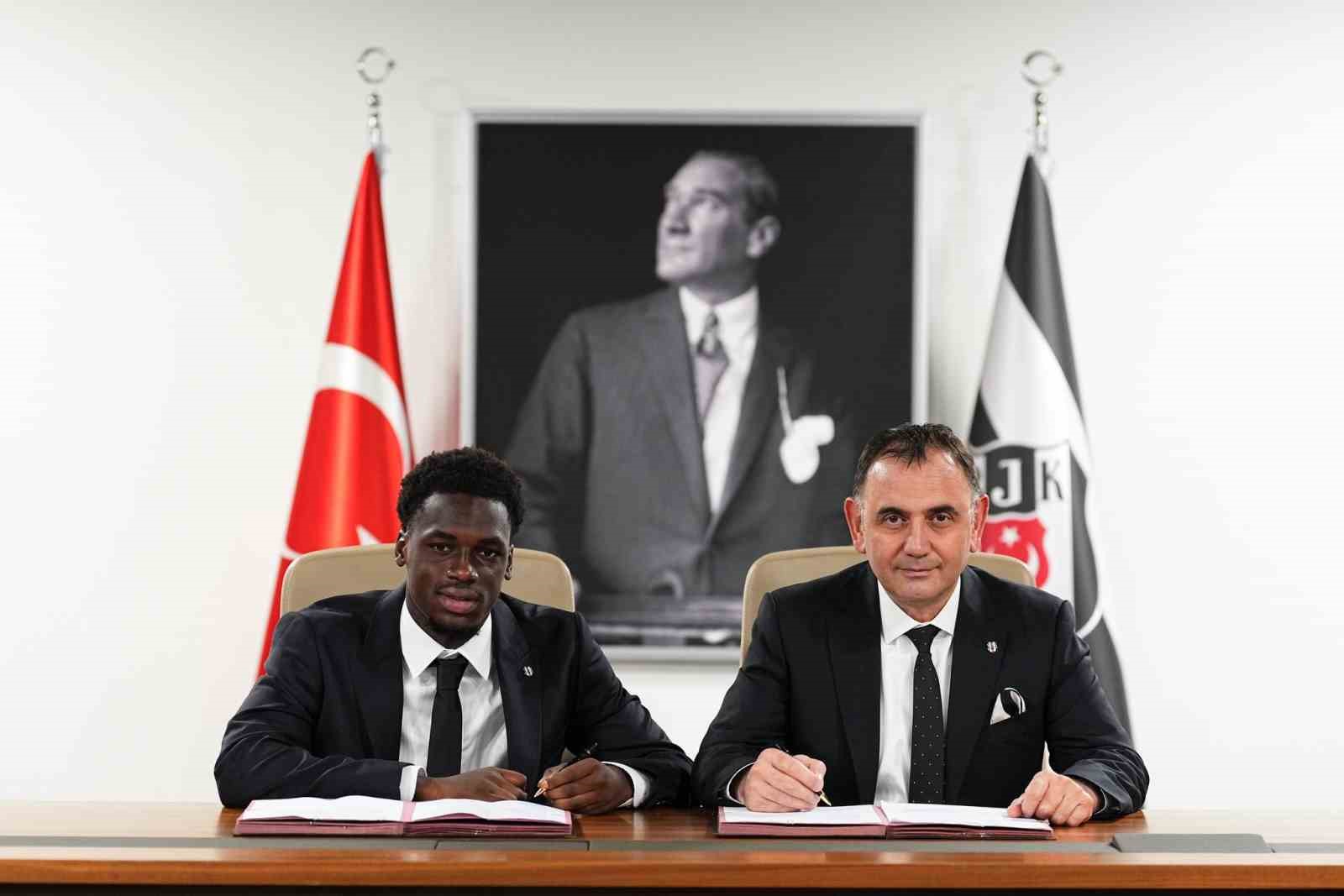 Ernest Poku ve Beşiktaş yetkilisi imza masasında görülüyor.