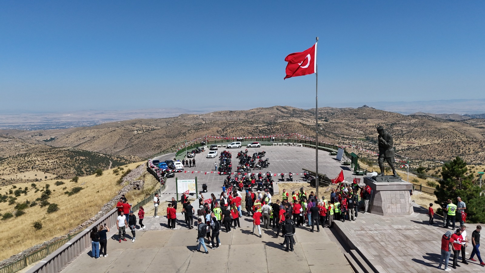 Motos garées sur le site de la cérémonie de Kocatepe, drapeau turc et participants.