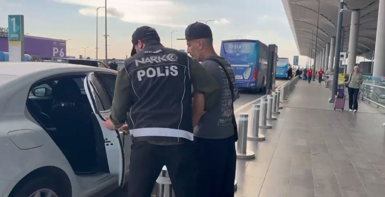 Bir kişinin polis eşliğinde araca bindirildiği görüntü.
