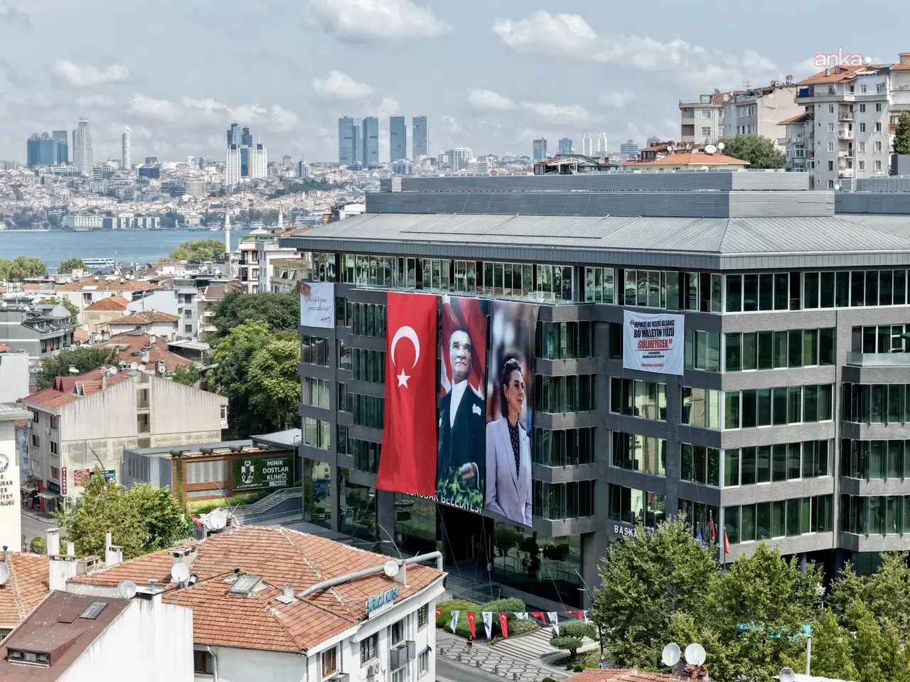 Üsküdar Belediyesi binası, çevredeki yapılar ve Boğaz manzarasıyla birlikte pankartların görüldüğü geniş açıdan görüntüleniyor.
