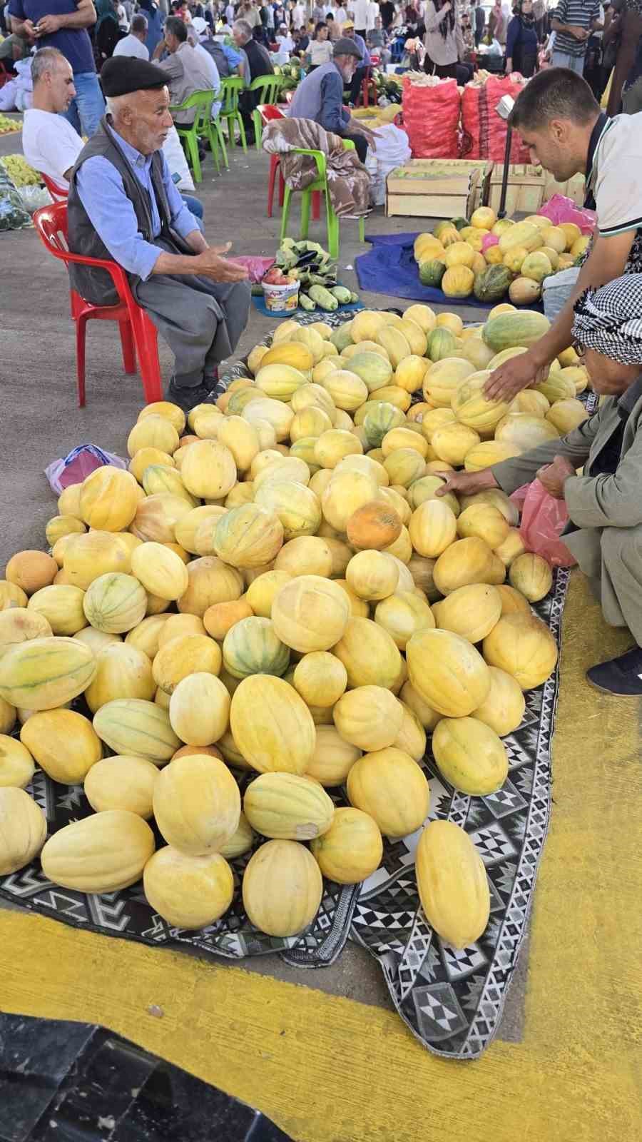 Diyarbakır’ın Çermik ilçesinde pazarda sergilenen sarı kavunlar ve alışveriş yapan vatandaşlar.