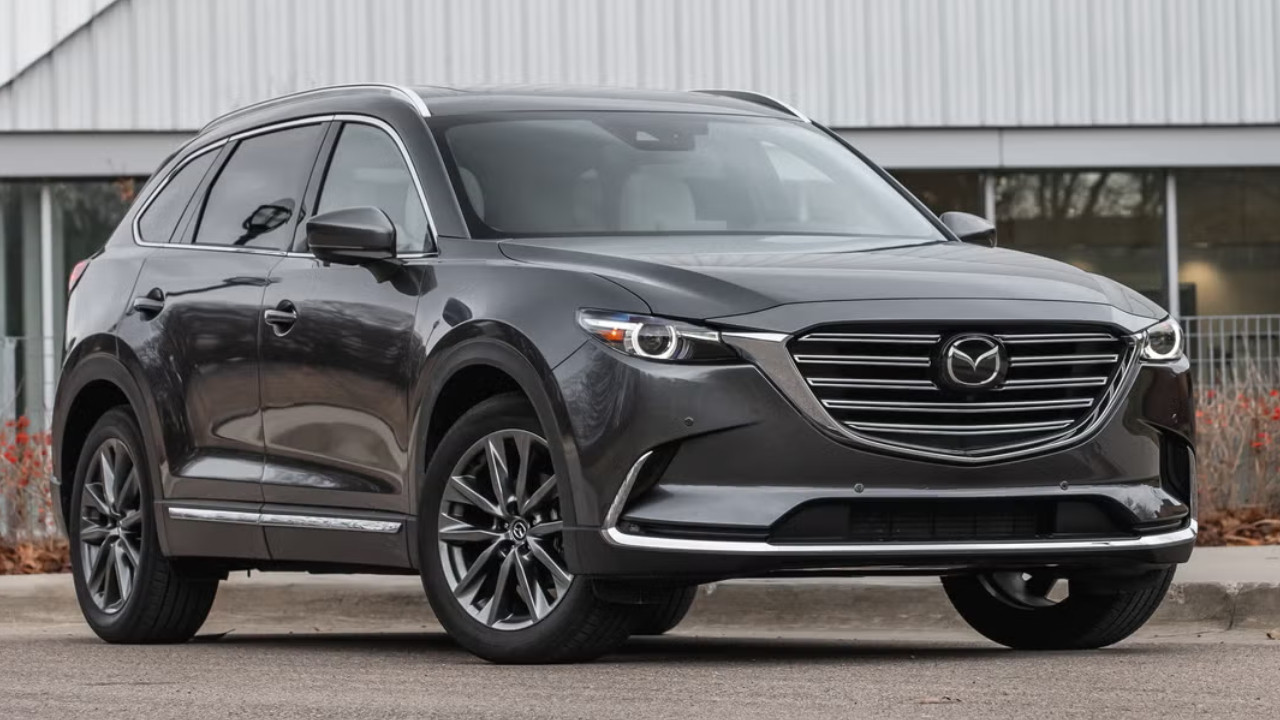 Mazda marka koyu renk bir SUV modelinin park halinde çekilmiş görseli.
