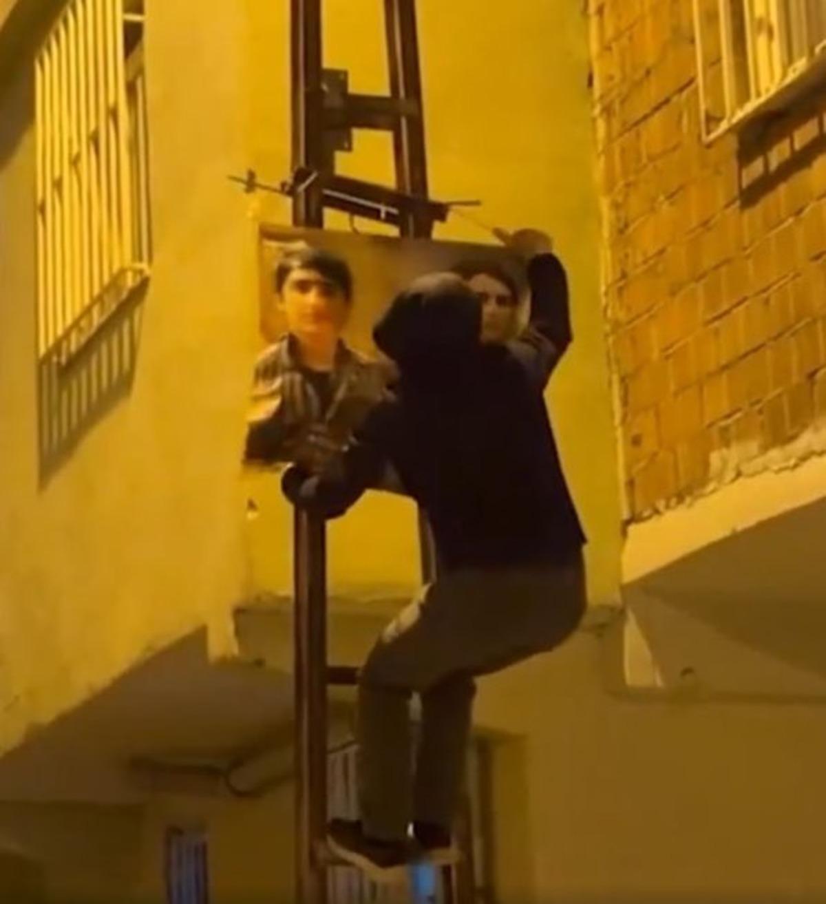 Footage showing a person hanging a poster on a wall at night in Diyarbakır.