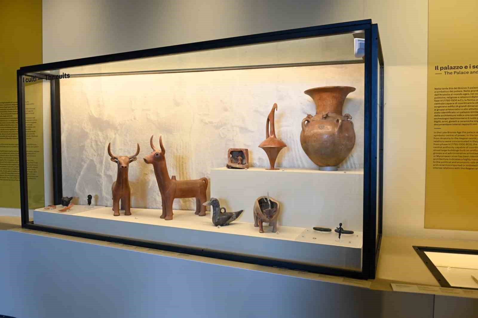 Terracotta vessels and figurines displayed in a glass showcase.