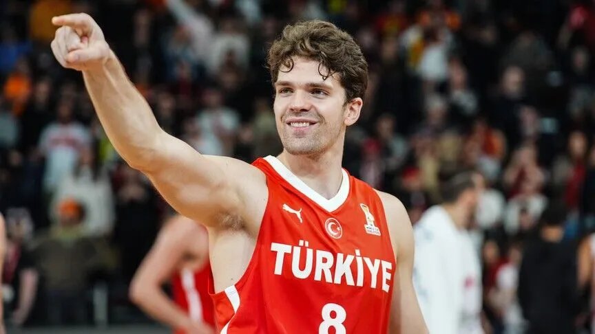 Türkiye formasıyla sahada görülen Tarık Biberovic, tribünlerin önünde işaret ediyor.