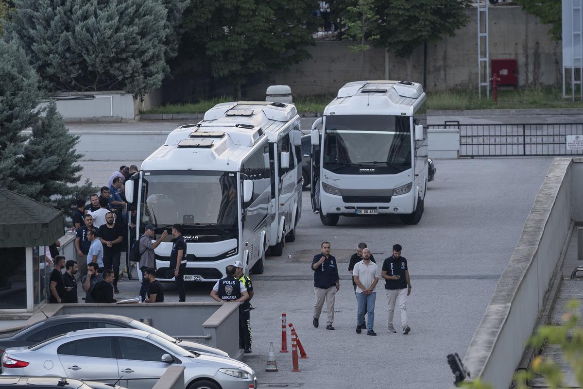 Adliye çevresinde polis ekipleri, otobüsler ve görevlilerin yer aldığı görüntü.
