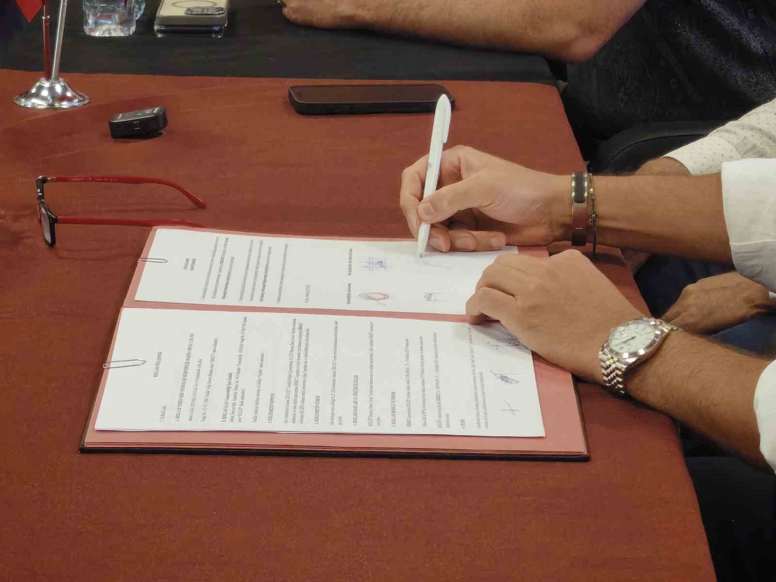 Sponsorluk sözleşmesinin imzalandığı anı gösteren yakın plan fotoğraf.