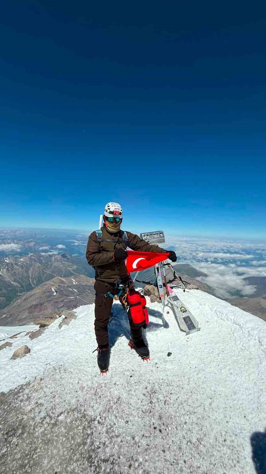 Elbrus Dağı zirvesinde Türk bayrağı tutan dağcı.