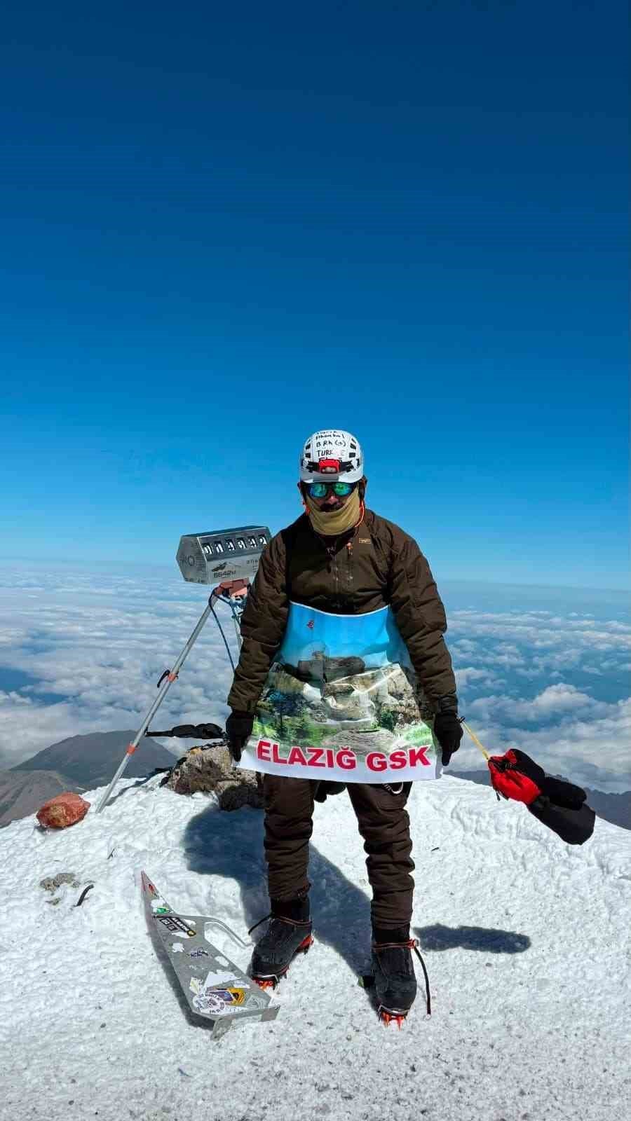 Elazığ GSK pankartı ile Elbrus zirvesinde duran dağcı.