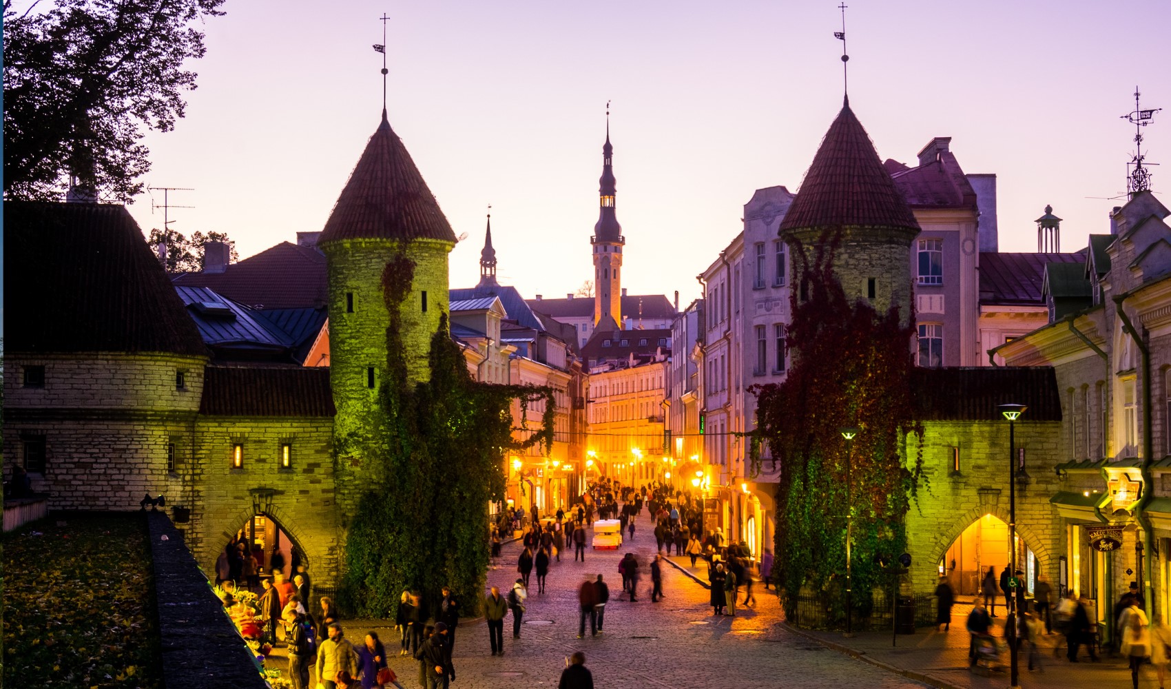 Tallinn’de tarihi kapıların ve taş sokakların akşam ışıkları altında görüntüsü.