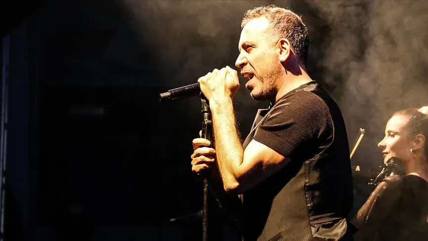 Haluk Levent sahnede mikrofonla şarkı söylerken görülüyor.