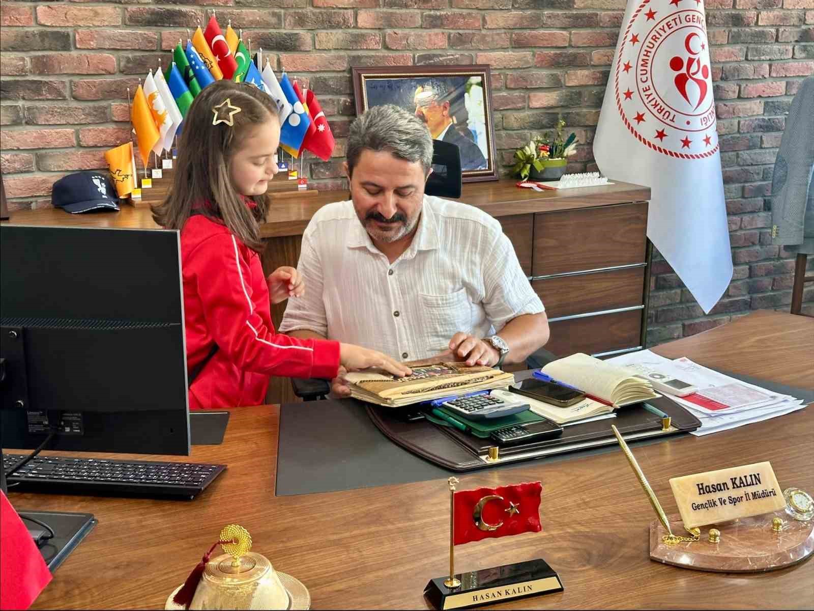 Elif Ertek, Eskişehir Gençlik ve Spor İl Müdürü Hasan Kalın’ın makamında bir albümü inceliyor.