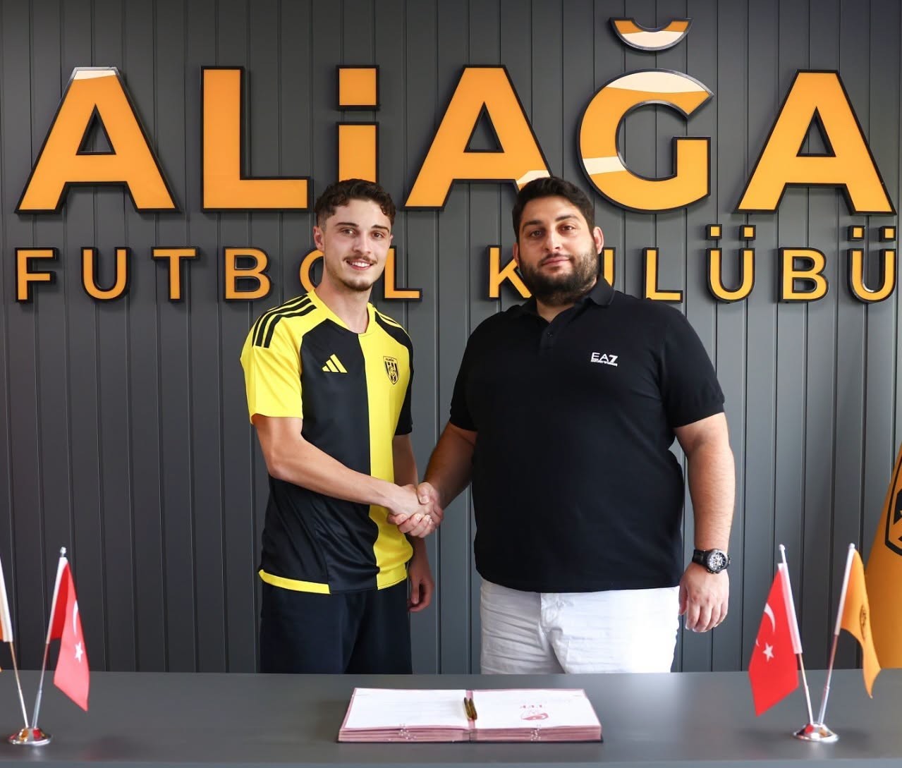 Ali Emir Pervanlar, Aliağa Futbol Kulübü Tesisleri’nde düzenlenen imza töreninde kulüp temsilcisiyle tokalaşıyor.