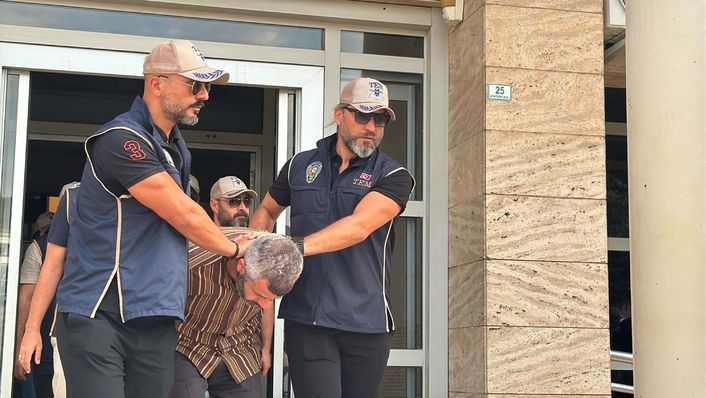 Güvenlik görevlilerinin Burkay Karatepe'yi bina çıkışında götürdüğü anlara ilişkin görüntü.
