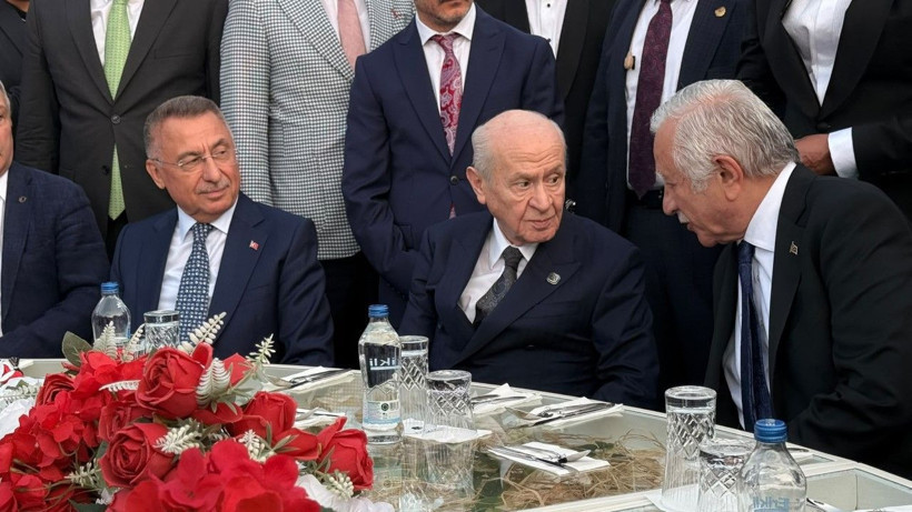 Devlet Bahçeli, protokol masasında diğer davetlilerle birlikte oturuyor.