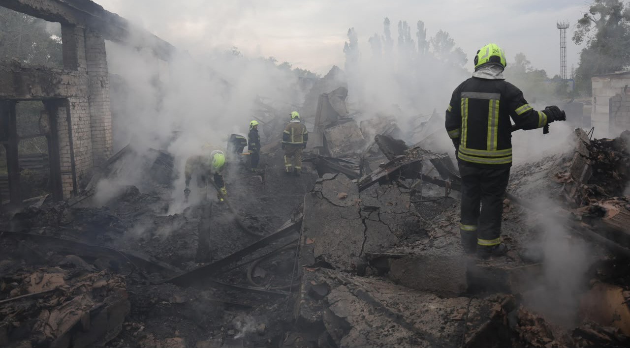 Kiev bölgesindeki enkaz alanında dumanlar arasında görev yapan itfaiyeciler.