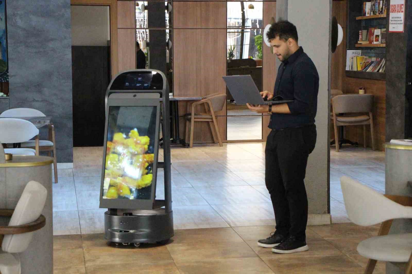 Bir restoran yetkilisinin Gayretli adlı servis robotunu kontrol ettiği görüntü.