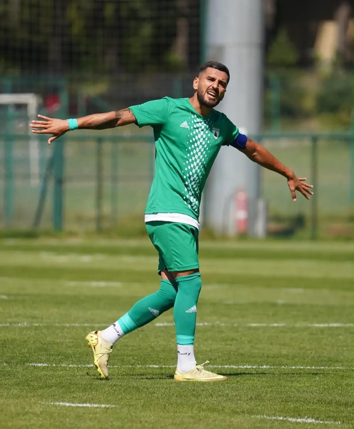 Muğlasporlu futbolcu sahada antrenman sırasında kolunu açarak yön gösteriyor.