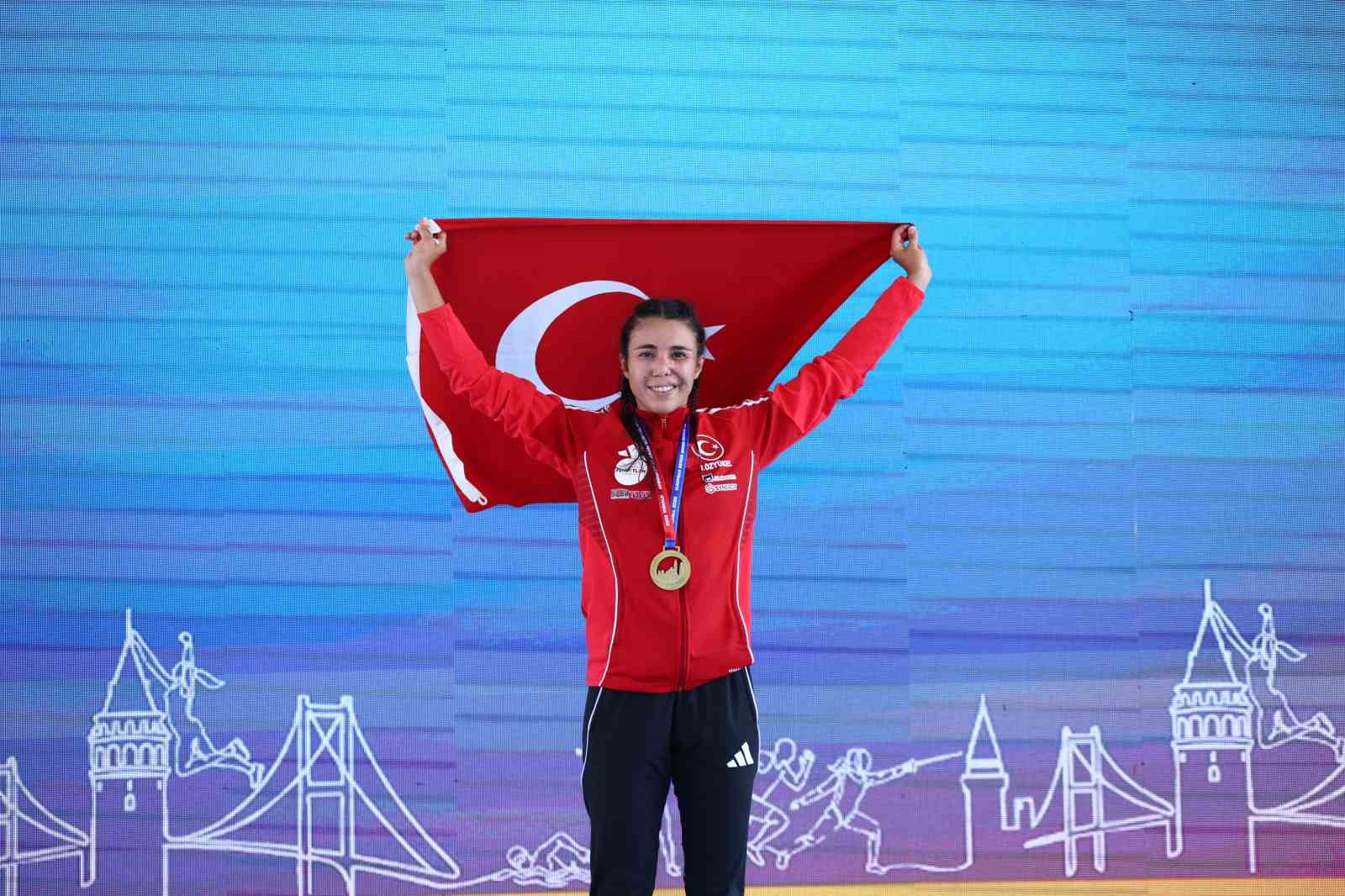 İlke Özyüksel Mihrioğlu, madalyasıyla podyumda Türk bayrağını kaldırıyor.