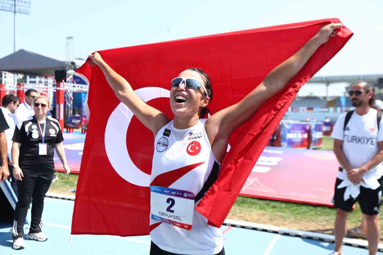 İlke Özyüksel Mihrioğlu, omzunda Türk bayrağıyla parkurda kutlama yapıyor.