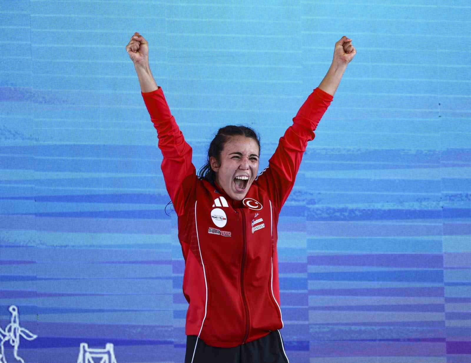 İlke Özyüksel Mihrioğlu, podyumda kollarını kaldırarak seviniyor.