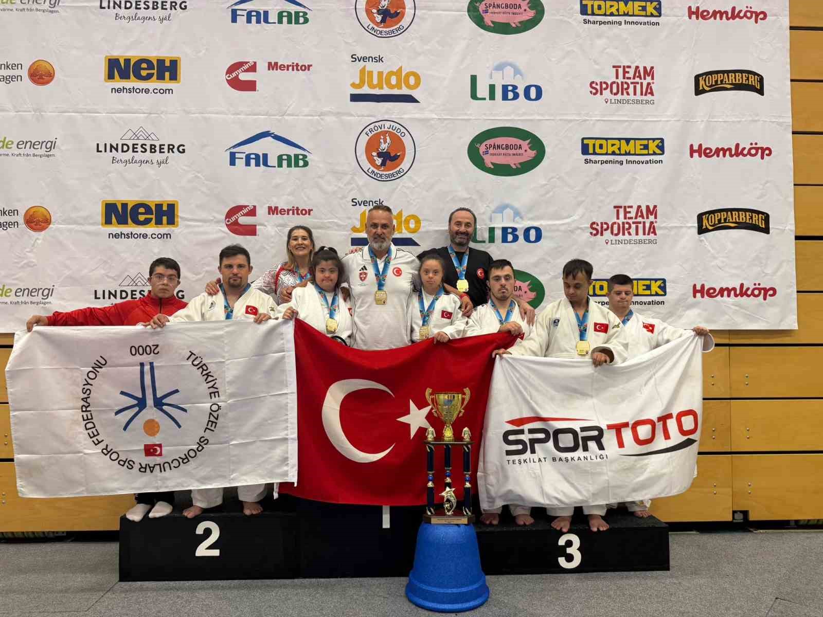 Özel Sporcular Judown Milli Takımı sporcuları, İsveç’te şampiyonluk kupası ve Türk bayrağıyla poz veriyor.