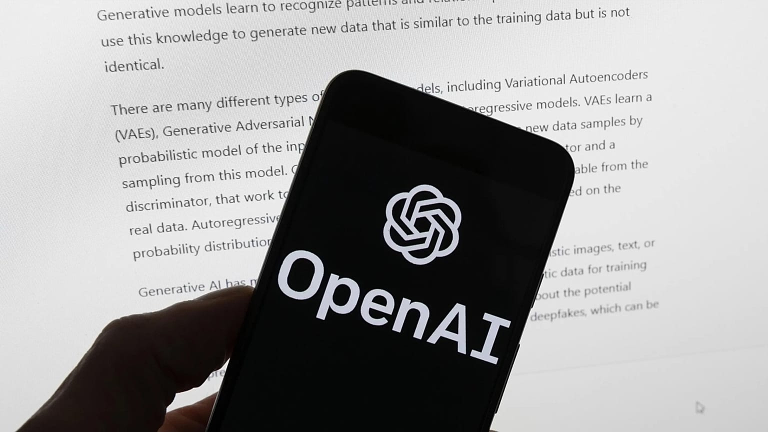 OpenAI logosunun yer aldığı telefon ekranı ve arka planda yapay zekâ metni.